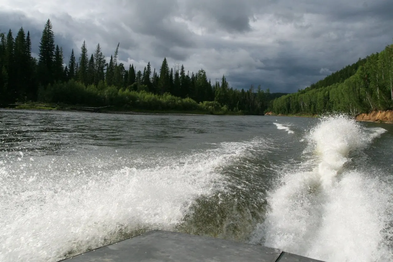 След моторной лодки на воде под грозовыми облаками